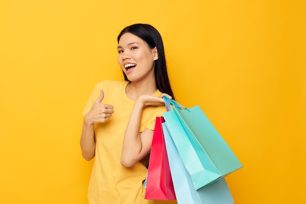 Retrato de uma bela jovem asiática com pacotes nas mãos comprando estilo de vida inalterado