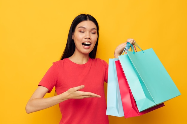 Retrato de uma bela jovem asiática com sacos coloridos posando um modelo de estúdio divertido de compras inalterado