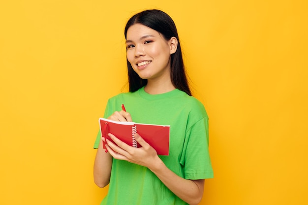 Retrato de uma bela jovem asiática, notebook e caneta, aprendendo o modelo de estúdio de educação inalterado