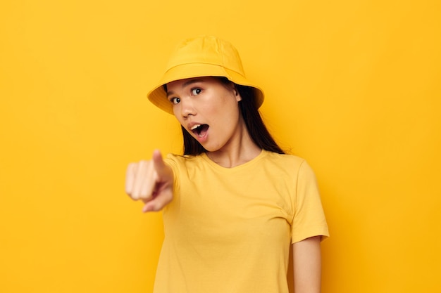 Foto retrato de uma bela jovem asiática usando um chapéu amarelo posando modelo de estúdio de emoções inalterado