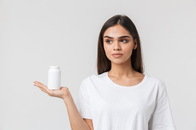 Foto retrato de uma bela jovem casual vestida de isolado no branco, mostrando o recipiente vazio