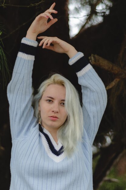 Foto retrato de uma bela jovem com os braços levantados.