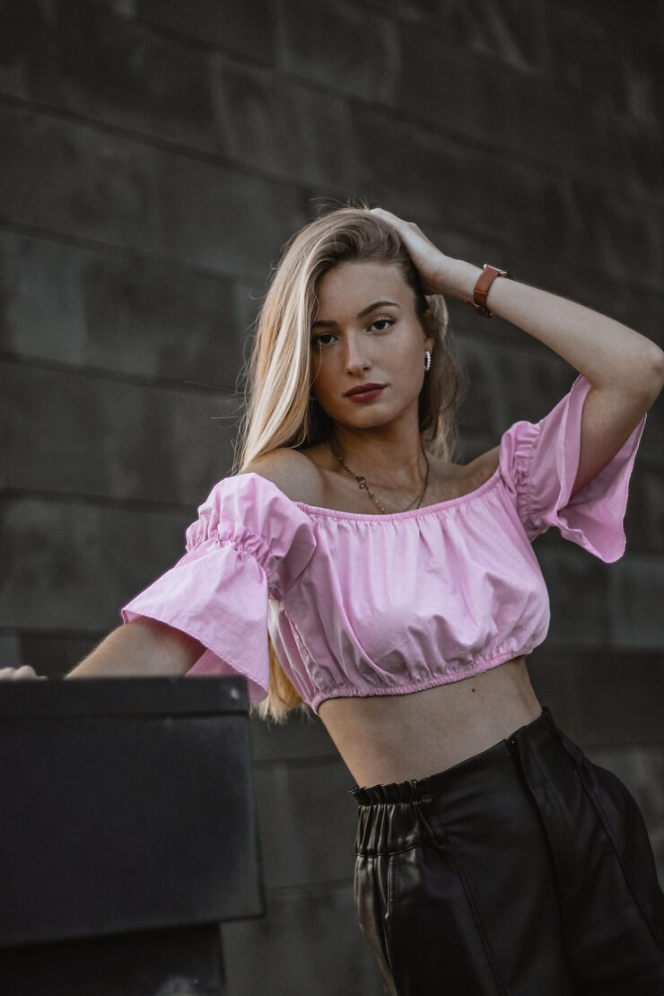 Foto retrato de uma bela jovem de pé contra a parede