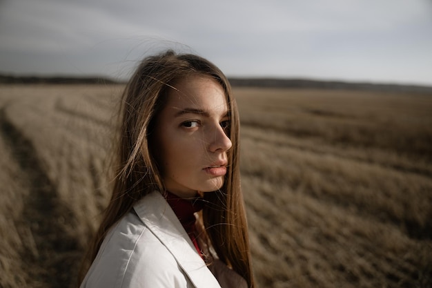 Retrato de uma bela jovem de pé em terra
