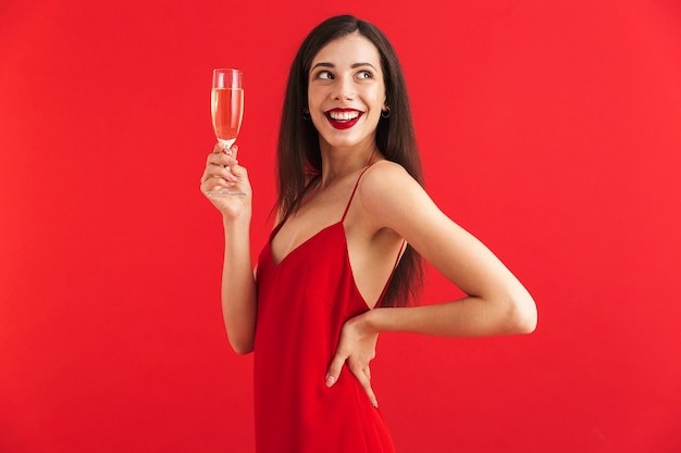 Retrato de uma bela jovem em vestido segurando uma taça de champanhe isolada