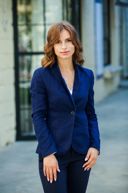 Retrato de uma bela jovem empresária em um terno azul ao ar livre