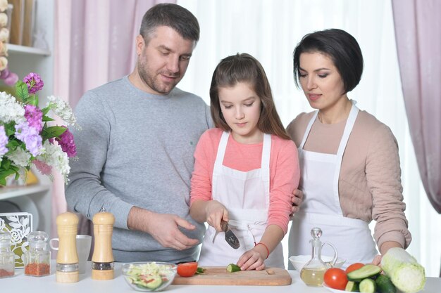 Retrato de uma bela jovem família cozinhando juntos na cozinha