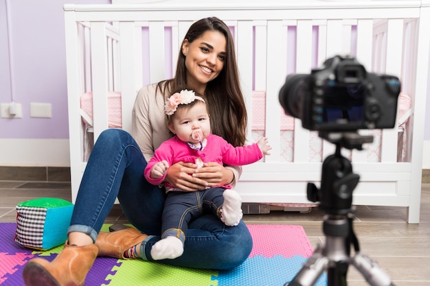 Foto retrato de uma bela jovem hispânica gravando um vídeo para seu blog sobre paternidade