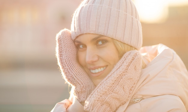 Retrato de uma bela jovem modelo de chapéu de malha rosa e luvas. natural linda jovem loira sorridente usando luvas de malha