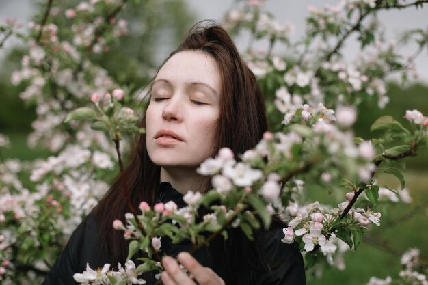 Retrato de uma bela jovem no jardim primavera entre flor de maçã