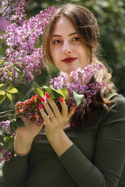 Retrato de uma bela jovem rodeada de flores lilás