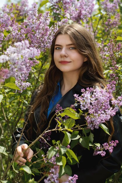 Retrato de uma bela jovem rodeada de flores lilás
