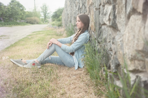 Retrato de uma bela jovem romântica na zona rural ao pôr do sol. garota atraente em roupas jeans