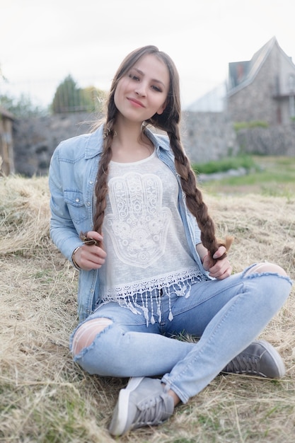 Foto retrato de uma bela jovem romântica na zona rural ao pôr do sol. garota atraente em roupas jeans