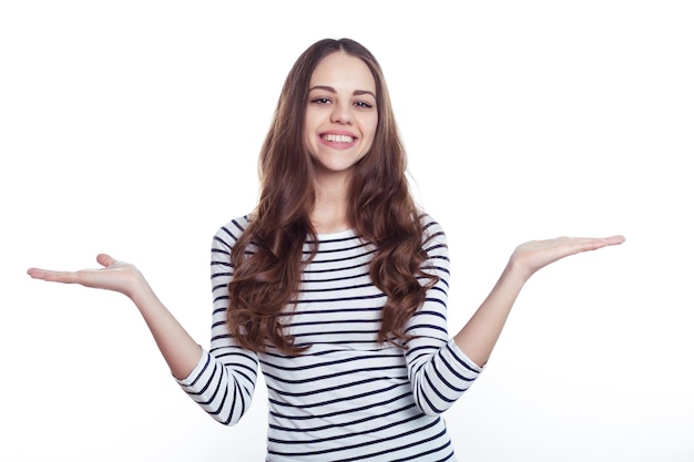 Retrato de uma bela jovem sorridente mulher moderna em roupas casuais que aponta seus dedos para algo