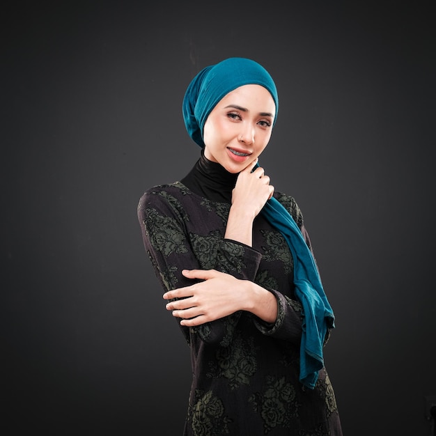 Retrato de uma bela modelo feminina muçulmana vestindo casualwear moderno com hijab isolado no escuro