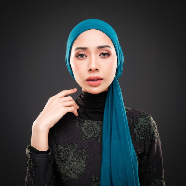 Retrato de uma bela modelo feminina muçulmana vestindo casualwear moderno com hijab isolado no escuro