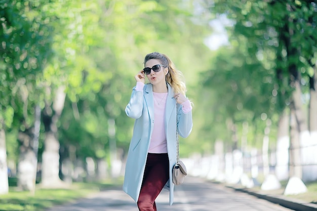 retrato de uma bela modelo feminino europeu usando óculos escuros / menina andando ao ar livre, garota alegre feliz usando óculos