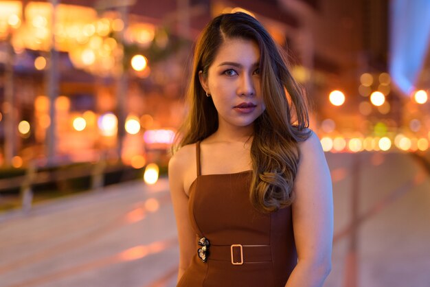 Retrato de uma bela mulher asiática ao ar livre em Bangkok, Tailândia, à noite