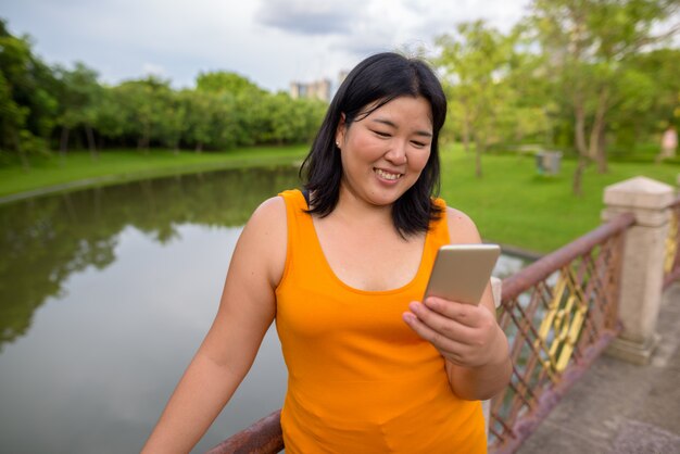 Retrato de uma bela mulher asiática com excesso de peso relaxando no parque na cidade de Bangkok, Tailândia