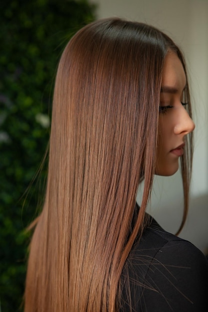 Foto retrato de uma bela mulher com cabelos longos castanhos e retos em um salão de beleza