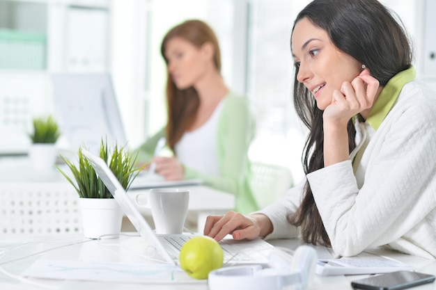 Retrato de uma bela mulher de negócios com um laptop no escritório