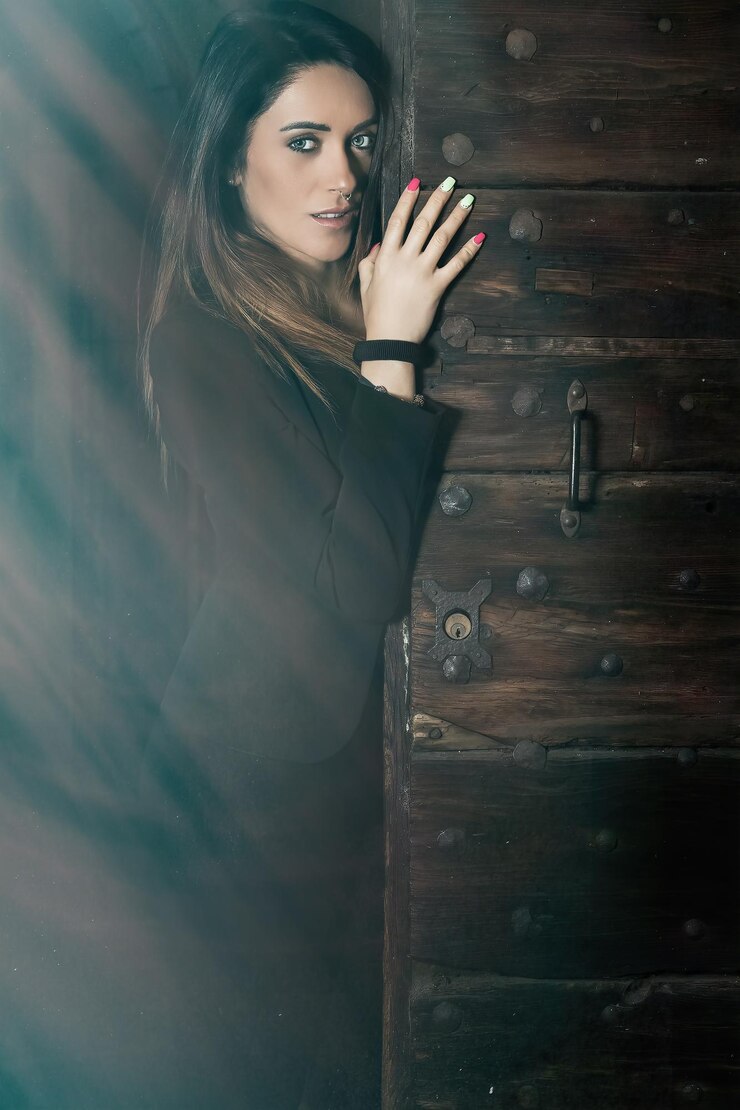 Foto retrato de uma bela mulher de pé à porta