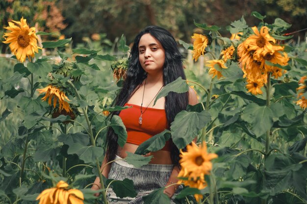 Foto retrato de uma bela mulher de pé no meio de plantas