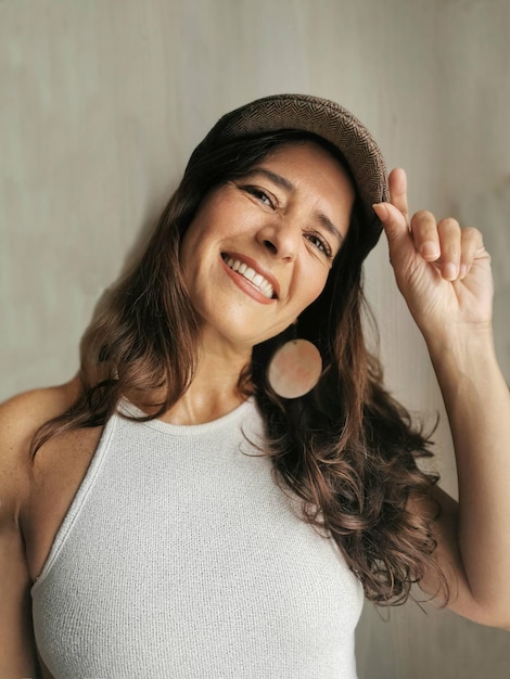 Retrato de uma bela mulher espanhola de meia-idade sorridente usando um boné