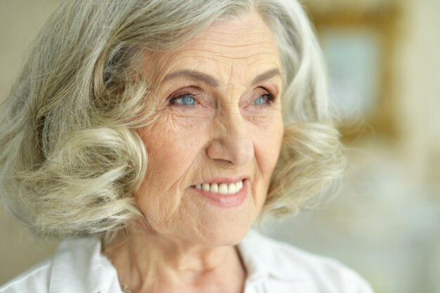 Foto retrato de uma bela mulher idosa sorridente posando em casa