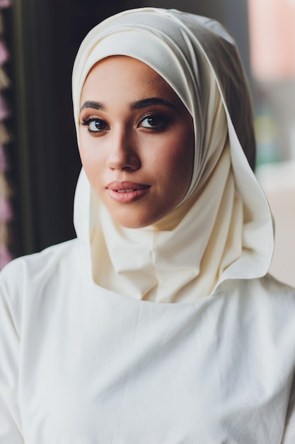 Retrato de uma bela mulher muçulmana em roupas islâmicas tradicionais e cobrindo a cabeça