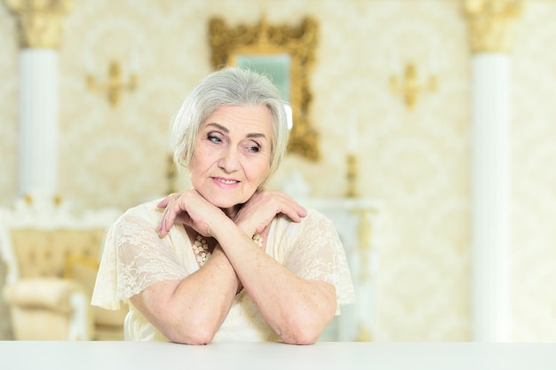 Retrato de uma bela mulher sênior com joias posando em casa