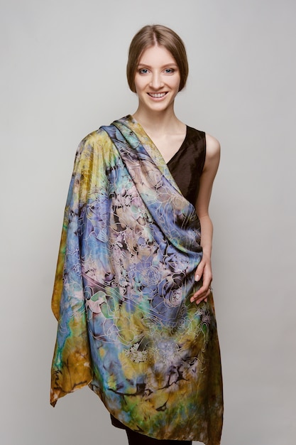 Retrato de uma bela mulher sorridente com xale de seda colorido