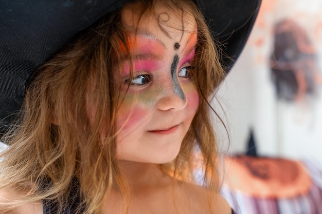 Retrato de uma criança com uma máscara pintada no rosto para o Halloween