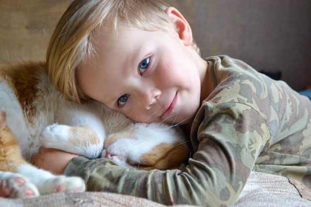 Retrato de uma criança de quatro anos com gato vermelho dormindo