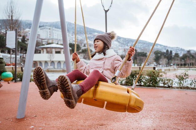 Foto retrato de uma criança feliz brincando no playground do parque