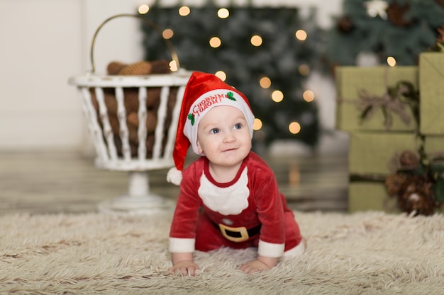 Retrato de uma criança fofa brincando no chão com cones para decorar a árvore de Natal.