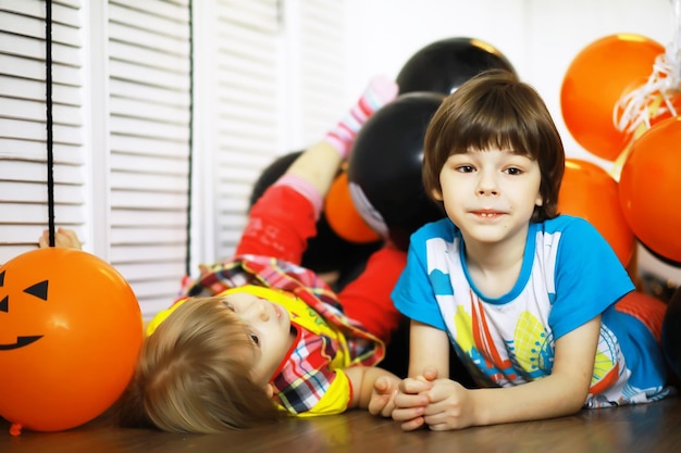 Retrato de uma criança pequena deitada no chão em uma sala decorada com balões Conceito de infância feliz