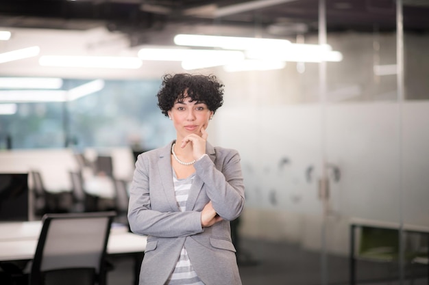Retrato de uma desenvolvedora de software bem-sucedida com um penteado encaracolado em um escritório de startups moderno