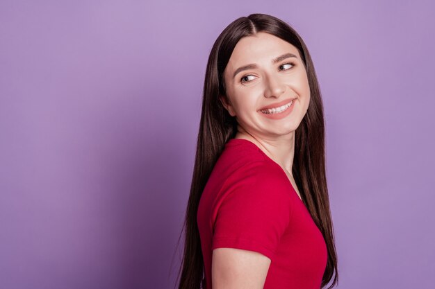 Retrato de uma doce e deslumbrante mulher alegre olhar o sonho do espaço em branco, pense no fundo violeta