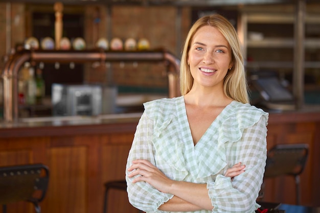 Retrato de uma dona sorridente, proprietária de um bar, restaurante ou cafeteria