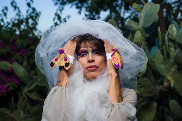 Retrato de uma drag queen em um cenário rural Pessoa de gênero não binário interagindo com a natureza