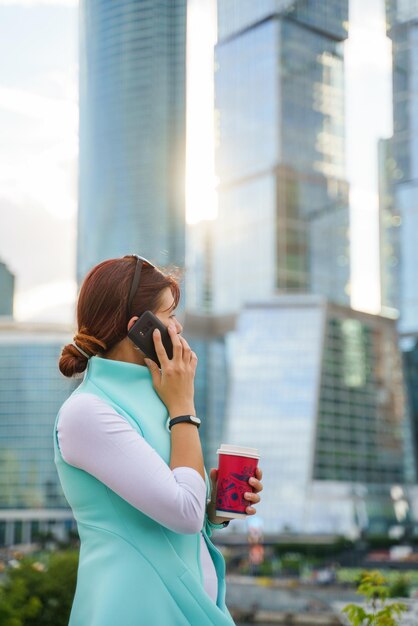 Retrato de uma empresária falando ao telefone com uma xícara de café