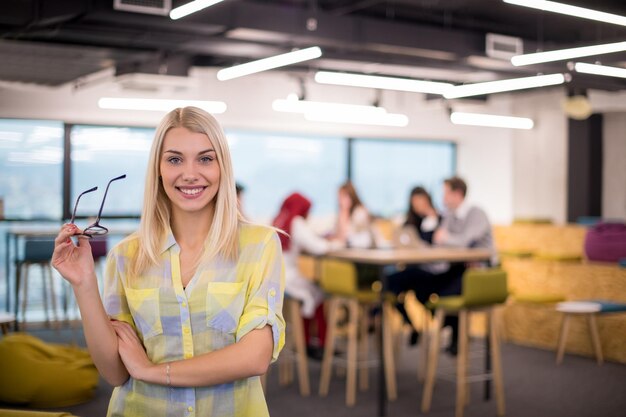 Retrato de uma empresária loira bem-sucedida no escritório de inicialização ocupado