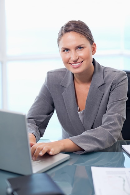 Retrato de uma empresária sorridente trabalhando com um laptop
