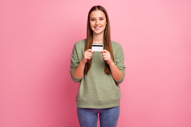 Retrato de uma encantadora alegre doce fofa linda garota segurando cartão de débito