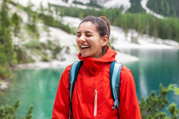 Foto retrato de uma encantadora mulher alpinista com belas montanhas de sorriso e lago ao redor