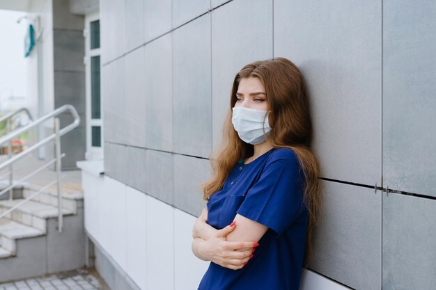 Retrato de uma enfermeira com máscara protetora fora da clínica Turno de trabalho difícil durante uma pandemia