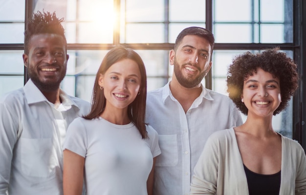 Foto retrato de uma equipe de negócios criativa bem-sucedida olhando para a câmera e sorrindo pessoas de negócios diversas de pé juntas na startup