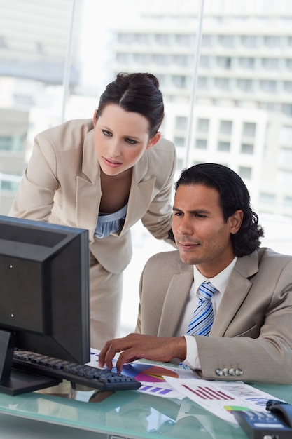 Retrato de uma equipe de negócios que estuda estatísticas ao usar um computador